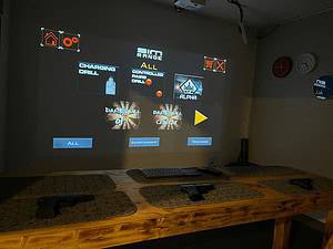 Virtual shooting simulator with game choices projected above the equipment table